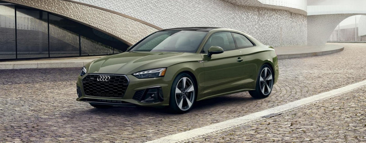 Green 2020 Audi A5 parked on a cobblestone street.